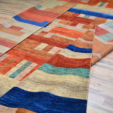 Load image into Gallery viewer, Colorful geometric-patterned rug on a wooden floor