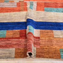 Load image into Gallery viewer, Multicolored geometric patterned rug on a wooden floor