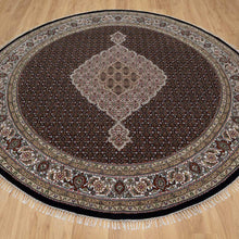 Load image into Gallery viewer, Round decorative rug with intricate patterns on a wooden floor