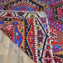 Load image into Gallery viewer, Close-up of a colorful patterned rug on a wooden floor