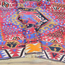Load image into Gallery viewer, Colorful patterned fabric with geometric designs on a wooden surface