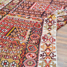Load image into Gallery viewer, Close-up of a patterned rug with intricate designs on a wooden floor.