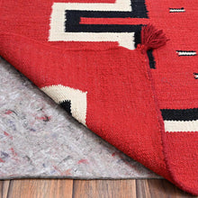 Load image into Gallery viewer, Close-up of a red patterned rug on a wooden floor