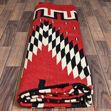 Load image into Gallery viewer, Folded red rug with geometric pattern on a wooden floor