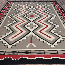 Load image into Gallery viewer, Geometric patterned rug with red, gray, and black colors on a wooden floor.