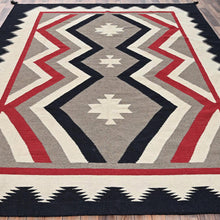 Load image into Gallery viewer, Geometric patterned rug with red, black, and gray colors on a wooden floor.