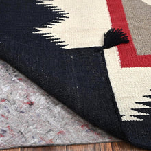 Load image into Gallery viewer, Close-up of a patterned rug with a tassel on a wooden floor.