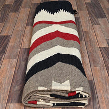 Load image into Gallery viewer, Folded blanket with red, gray, and black stripes on a wooden floor