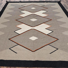 Load image into Gallery viewer, Geometric patterned rug with diamond shapes on a wooden floor