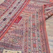 Load image into Gallery viewer, Close-up of a patterned rug with intricate designs on a wooden floor.