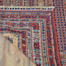 Load image into Gallery viewer, Close-up of a patterned rug on a wooden floor