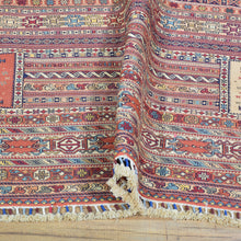 Load image into Gallery viewer, Close-up of a patterned rug with fringes on a wooden floor