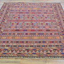 Load image into Gallery viewer, Multicolored patterned rug on a wooden floor