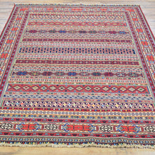 Load image into Gallery viewer, Multicolored patterned rug on a wooden floor