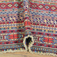 Load image into Gallery viewer, Colorful patterned fabric with tassels on a wooden surface