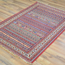 Load image into Gallery viewer, Decorative rug with intricate patterns on a wooden floor
