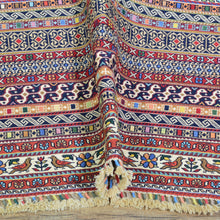 Load image into Gallery viewer, Colorful patterned fabric with tassels on a wooden surface