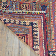 Load image into Gallery viewer, Close-up of a colorful patterned rug on a wooden floor