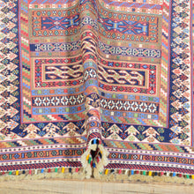 Load image into Gallery viewer, Close-up of a colorful patterned fabric with intricate designs on a wooden surface.