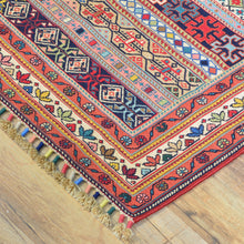 Load image into Gallery viewer, Colorful patterned rug with tassels on a wooden floor